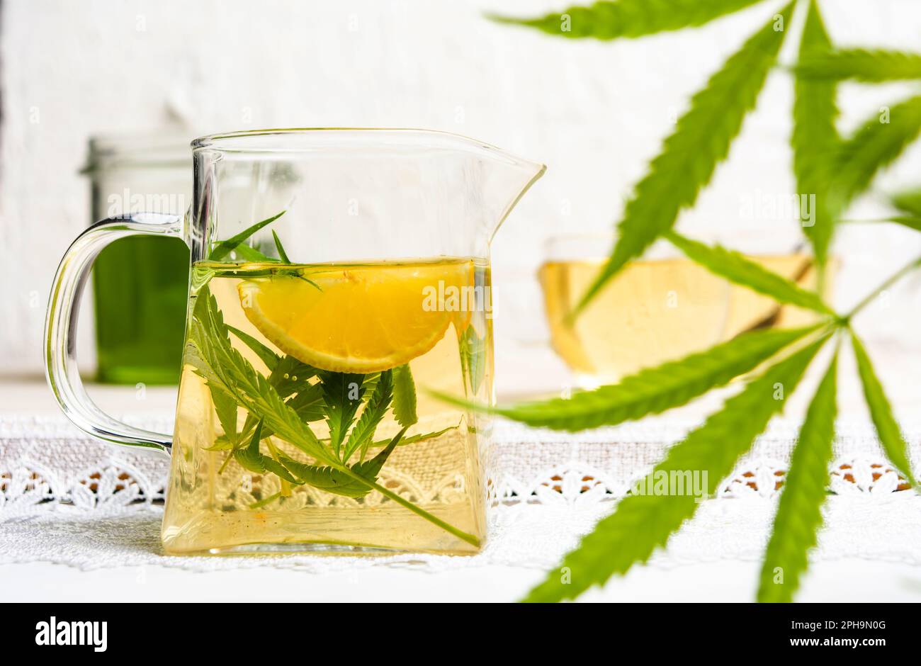 Cannabis tea with lemon and marijuana leaves in a glass Stock Photo