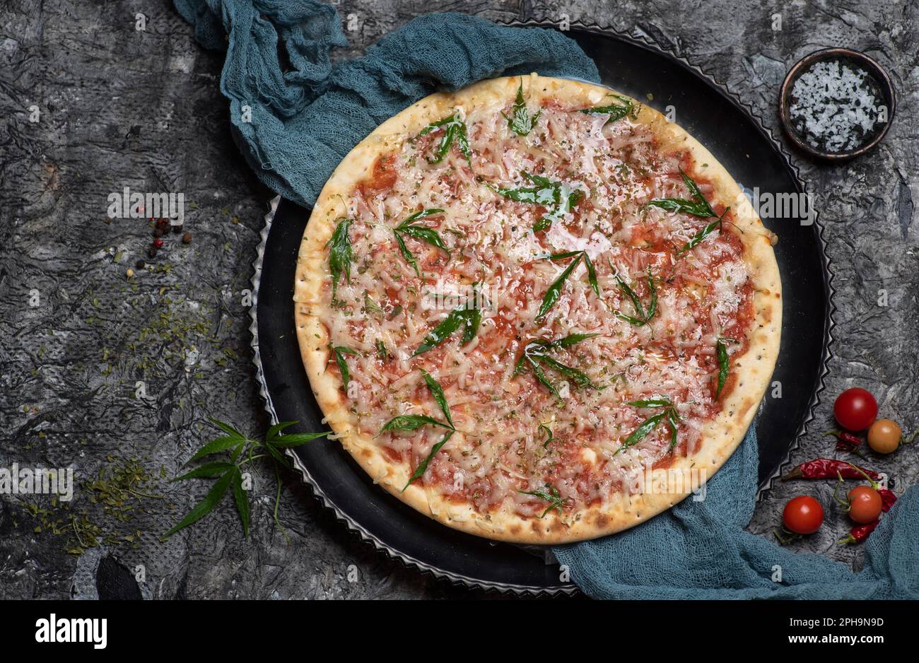 Happy pizza. Pizza with cannabis decorated with marijuana leaves top view Stock Photo