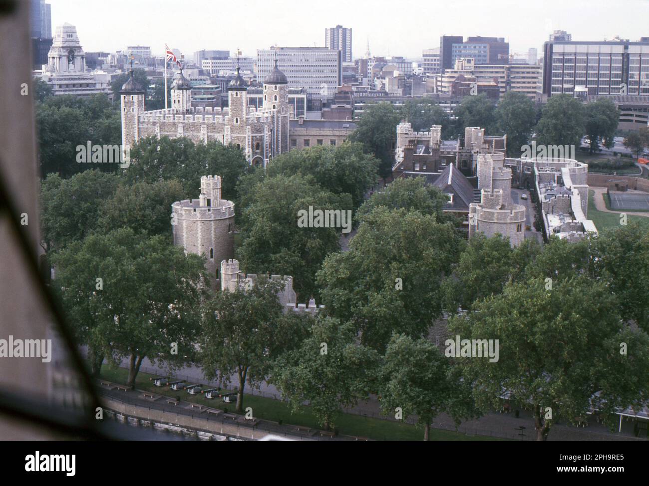 London. 1984. A view of the Tower of London from the upper footway of Tower Bridge, spanning the River Thames in London, England. Visible to the left is the Port of London Authority Building, 10 Trinity Square at Tower Hill, the former headquarters of the Port of London Authority. Stock Photo