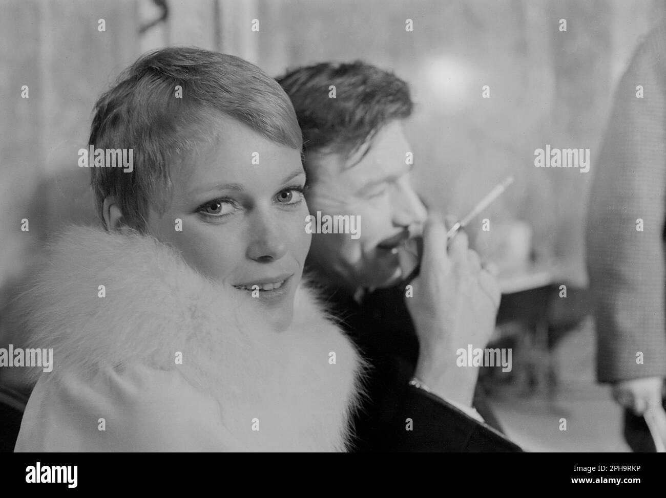 London. circa.1967. A photograph of Mia Farrow and Laurence Harvey inside the Café Royal, Regent Street in Piccadilly, London, taken behind the scenes during the filming of the neo-noir British spy movie, ‘A Dandy in Aspic’. The film was directed by Anthony Mann. Stock Photo