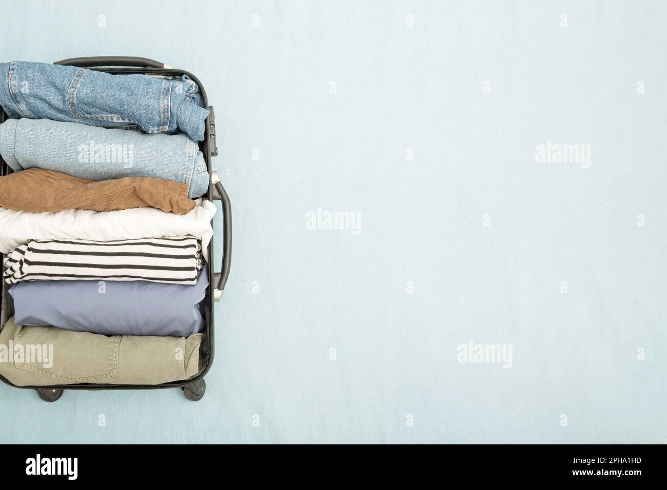 An open suitcase with neatly folded konmari clothes vertically. The