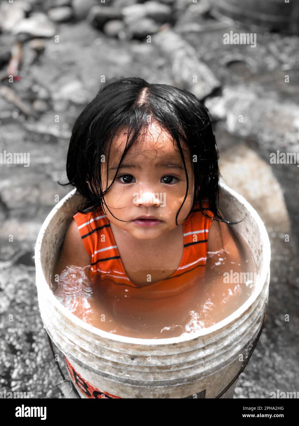 Baby bathing in a bucket of water Stock Photo