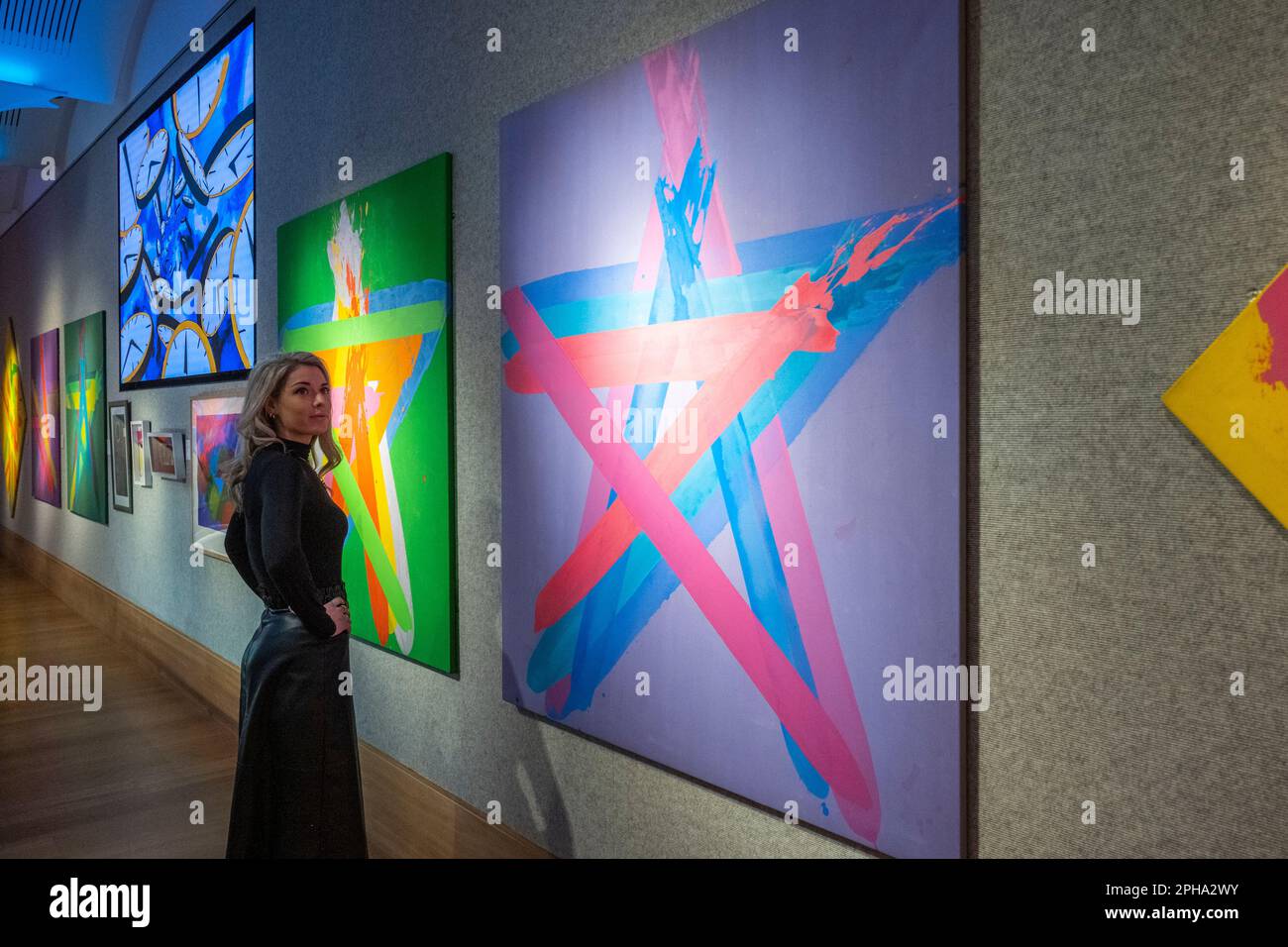London, UK.  27 March 2023. A staff member poses with (R)“Star XVIII” 1988, by John Copnall (Est. £1,000 - £1,500) at a preview of Bonham’s ‘British. Cool.’ sale.  British art, prints, fashion, photographs and popular culture memorabilia will be offered for sale at Bonham’s New Bond Street galleries on 29 March  Credit: Stephen Chung / Alamy Live News Stock Photo