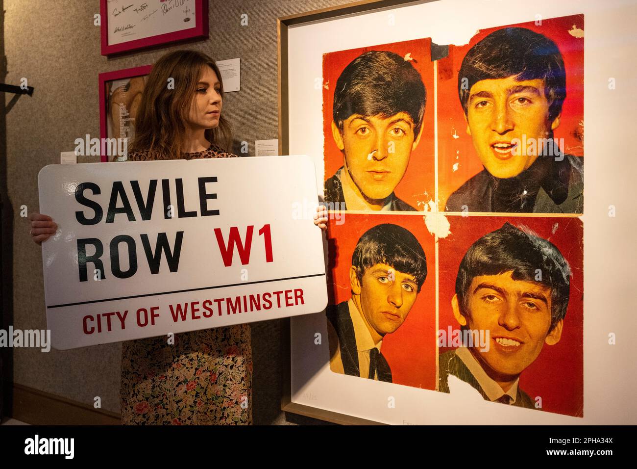 London, UK.  27 March 2023. A staff member holds “A Metal Street Sign For 'Savile Row' In London, Home of The Beatles' Apple Offices”, 1980s/90s, The Beatles (Est. £1,500 - £2,000) next to “Found Art - 'Beatles 62'”, 2012, by Peter Blake (Est. £2,500 - £3,500) at a preview of Bonham’s ‘British. Cool.’ sale.  British art, prints, fashion, photographs and popular culture memorabilia will be offered for sale at Bonham’s New Bond Street galleries on 29 March  Credit: Stephen Chung / Alamy Live News Stock Photo