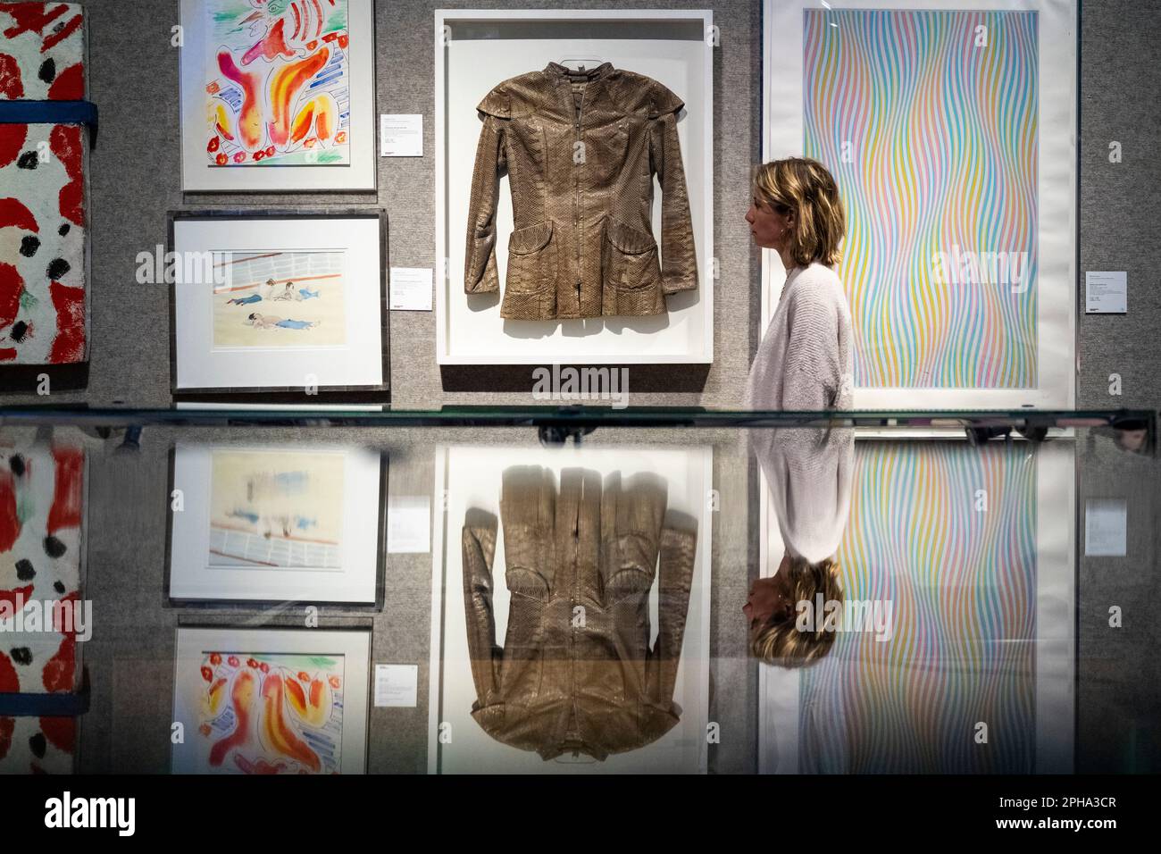 London, UK.  27 March 2023. A staff member views (C) “Framed Python Skin Jacket”, circa 1966, by Ossie Clark (Est. £600 - £800) at a preview of Bonham’s ‘British. Cool.’ sale.  British art, prints, fashion, photographs and popular culture memorabilia will be offered for sale at Bonham’s New Bond Street galleries on 29 March  Credit: Stephen Chung / Alamy Live News Stock Photo