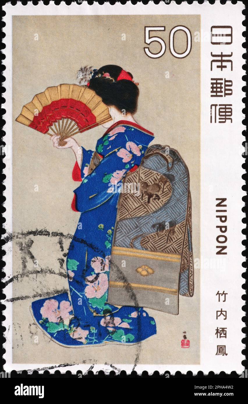 Geisha with fan on japanese postage stamp Stock Photo