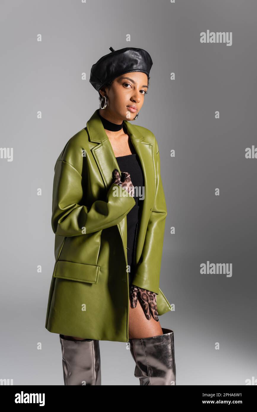 Fashionable african american model in leather beret and coat posing ...