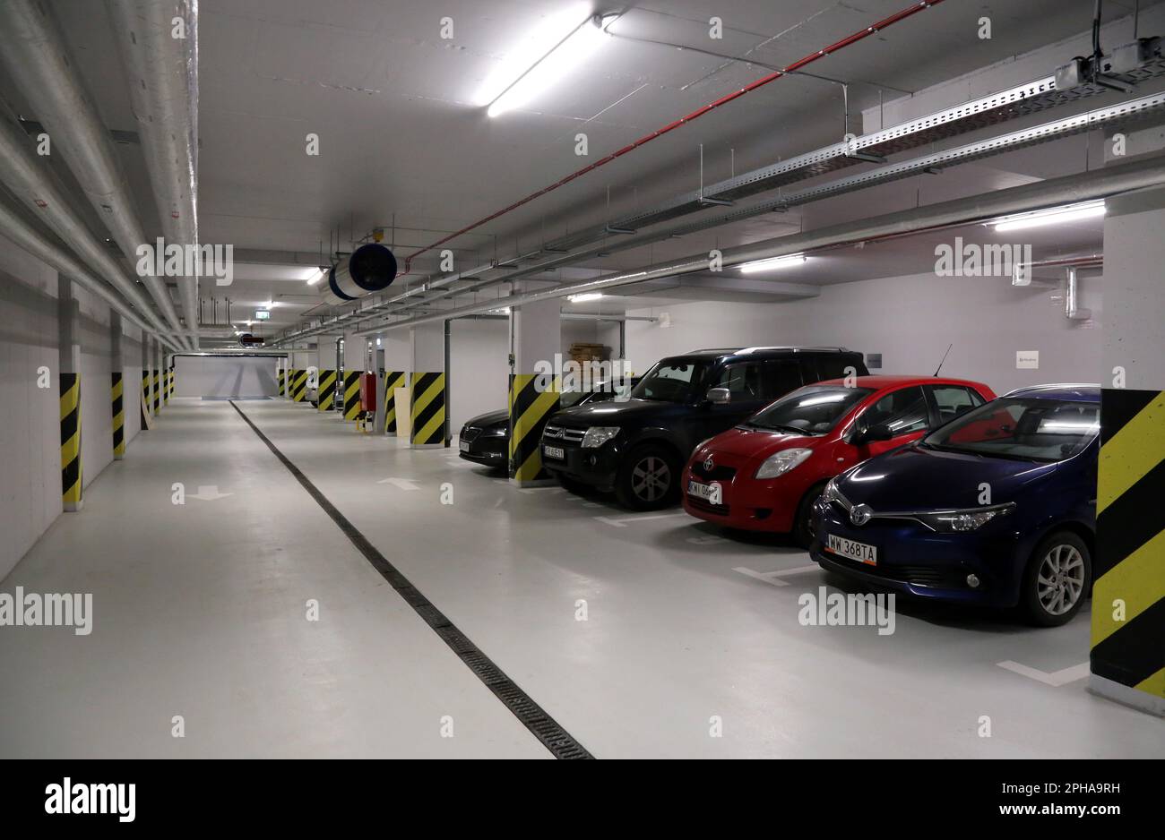 Cars in Underground parking garage in modern office building Stock