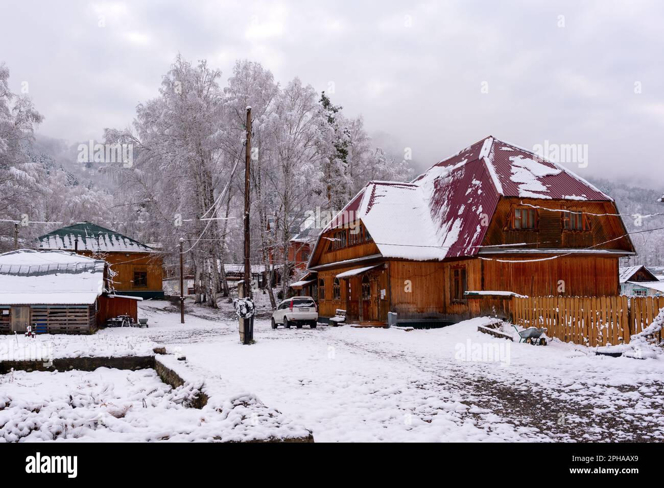 The car stands at a wooden cottage in the snow in a village in Russia ...