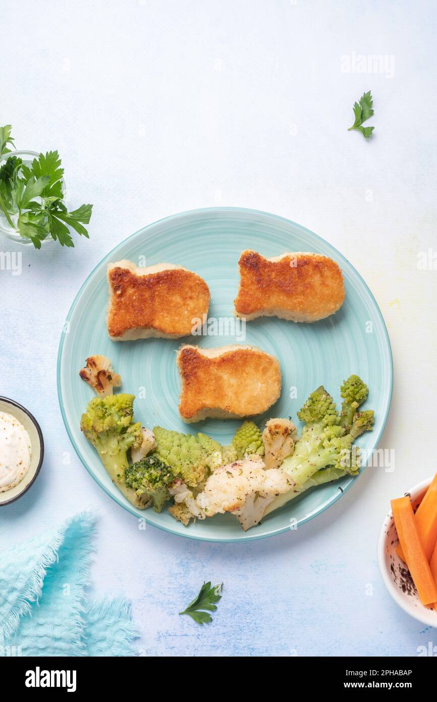Kids food. Fish shaped nuggets with vegetable Stock Photo - Alamy