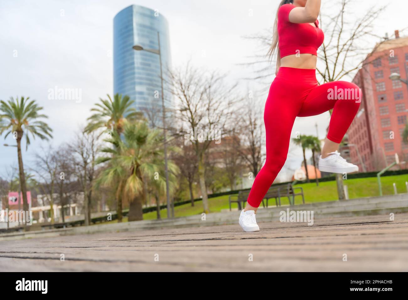 An athlete woman in red clothes running fast in the city, fitness, sport Stock Photo