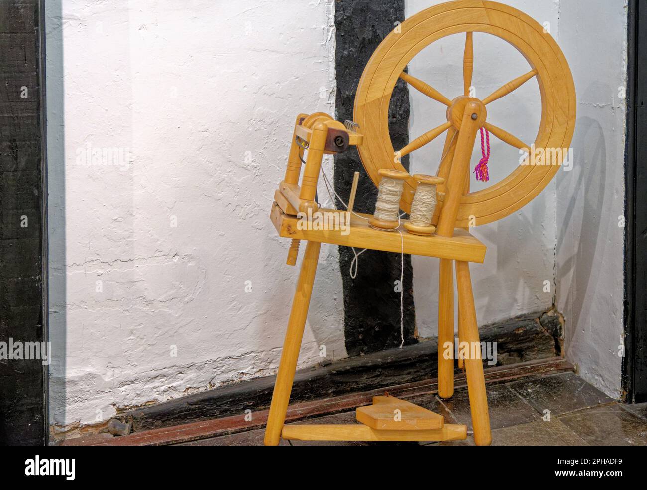 Antique spinning wheel. Nice ancient wooden spinning wheel at Tudor House Museum Worcester, Worcestershire, England, United Kingdom - 28th of January Stock Photo