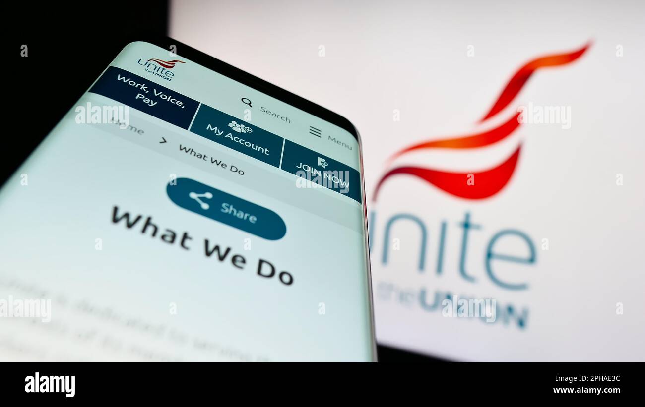 Mobile phone with website of British trade union Unite the Union on screen in front of logo. Focus on top-left of phone display. Stock Photo