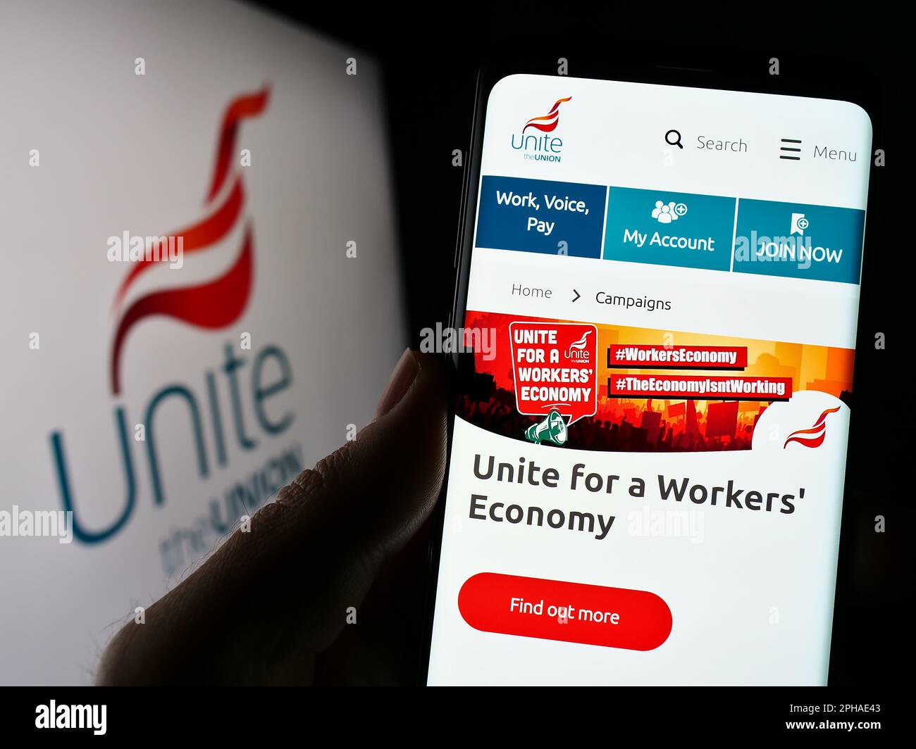Person holding smartphone with webpage of British trade union Unite the Union on screen in front of logo. Focus on center of phone display. Stock Photo