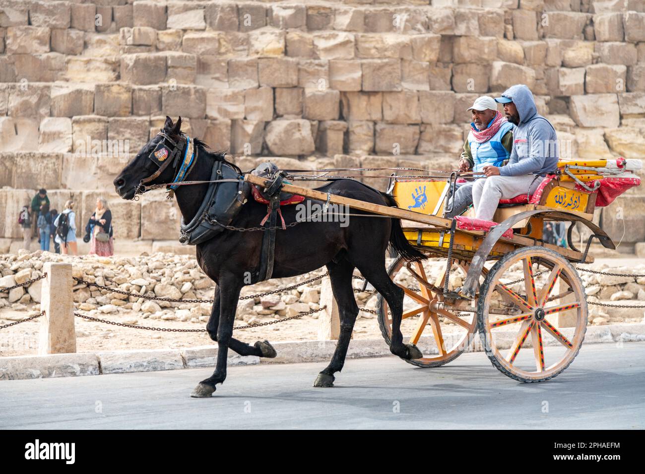 People riding a horse cart at the Pyramids of Giza complex in Egypt