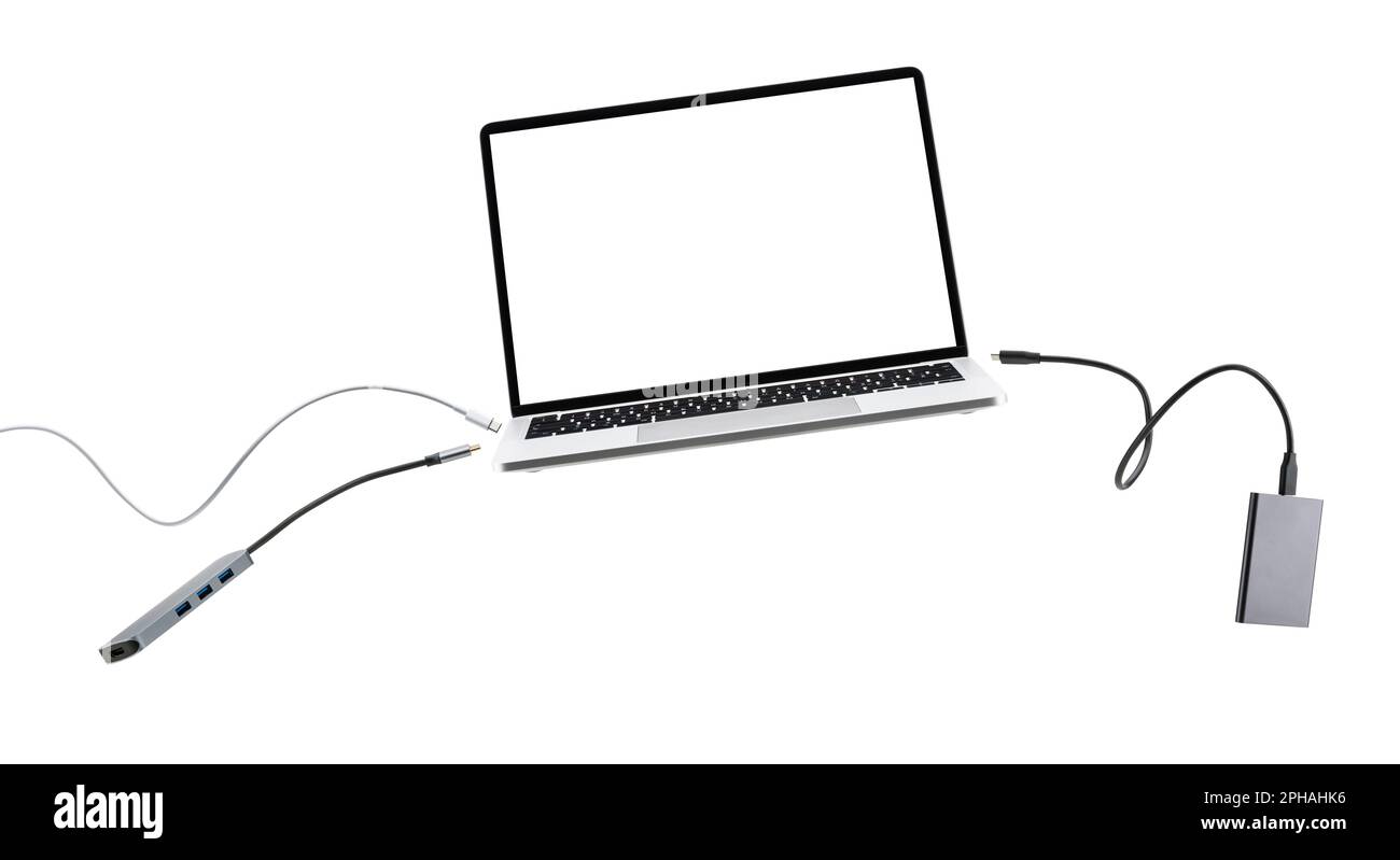 Laptop with cables and devices floating on white background. Stock Photo