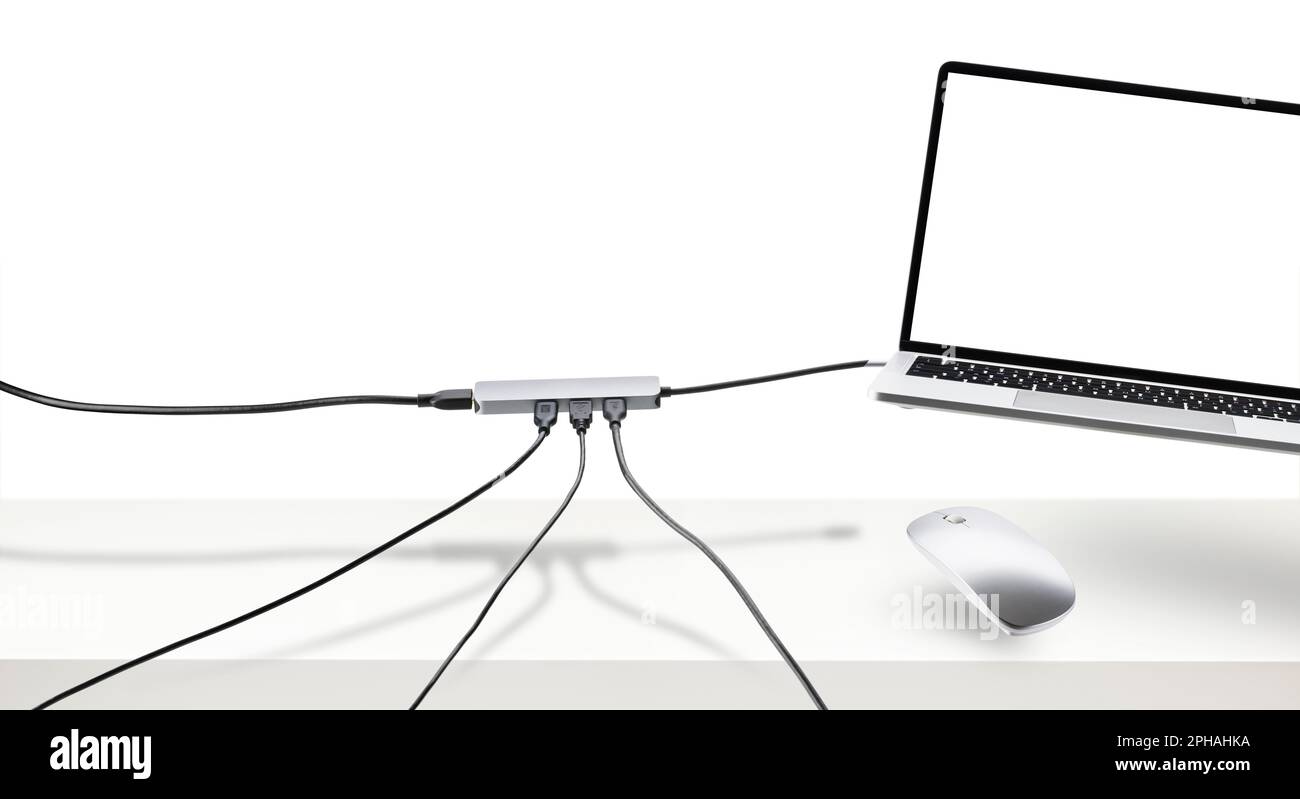Laptop on white desk with floating mouse and cable. Connection concept. Stock Photo