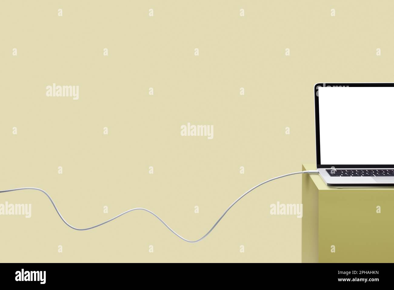 Laptop on colored pedestal with cable. Yellow background. Connection concept. Stock Photo