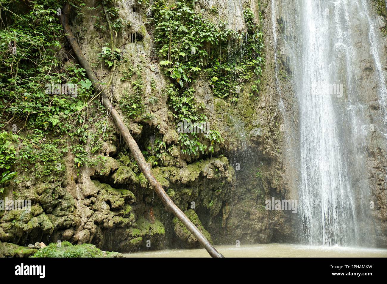 The idyllic Cangbangang Waterfalls in Siquijor in the Philippines surrounded by the light-lit rainforest. Stock Photo