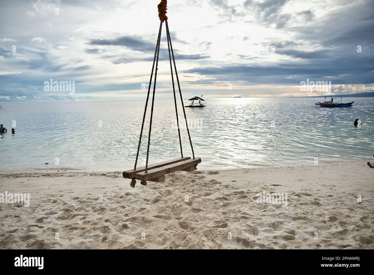 Dreamlike idyllic beach of Siquijor in the Philippines with a wooden swing in focus. Stock Photo