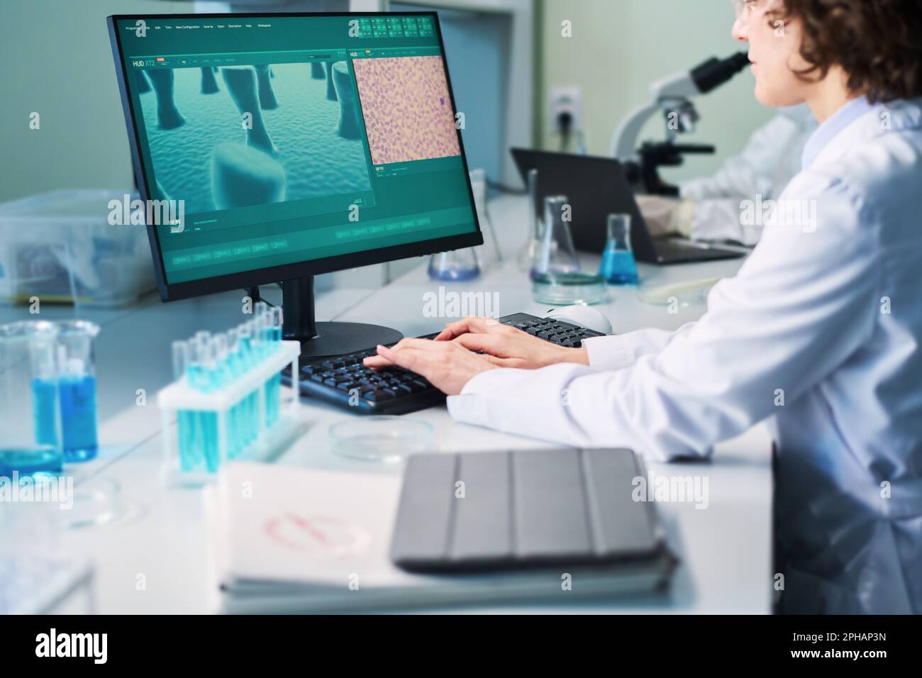Young female researcher carrying out clinical experiment while sitting ...