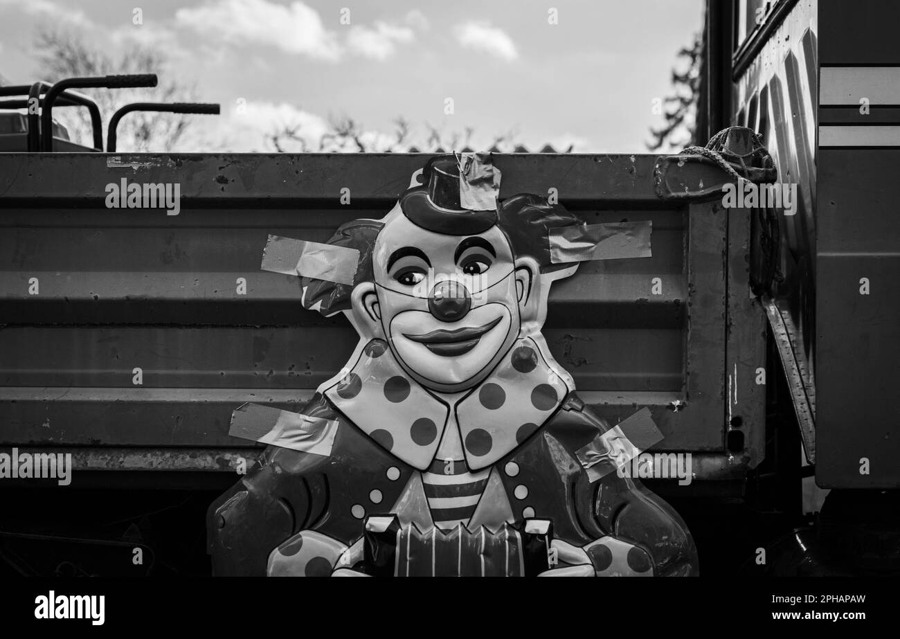 A greyscale of a clown poster attached to an ld truck with duct tape Stock Photo