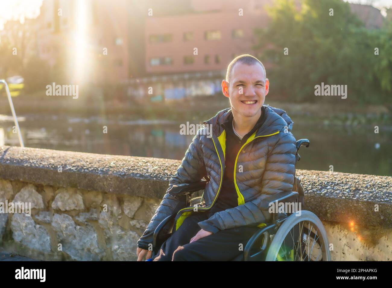 A disabled person in a wheelchair enjoying the sunny day in an urban ...