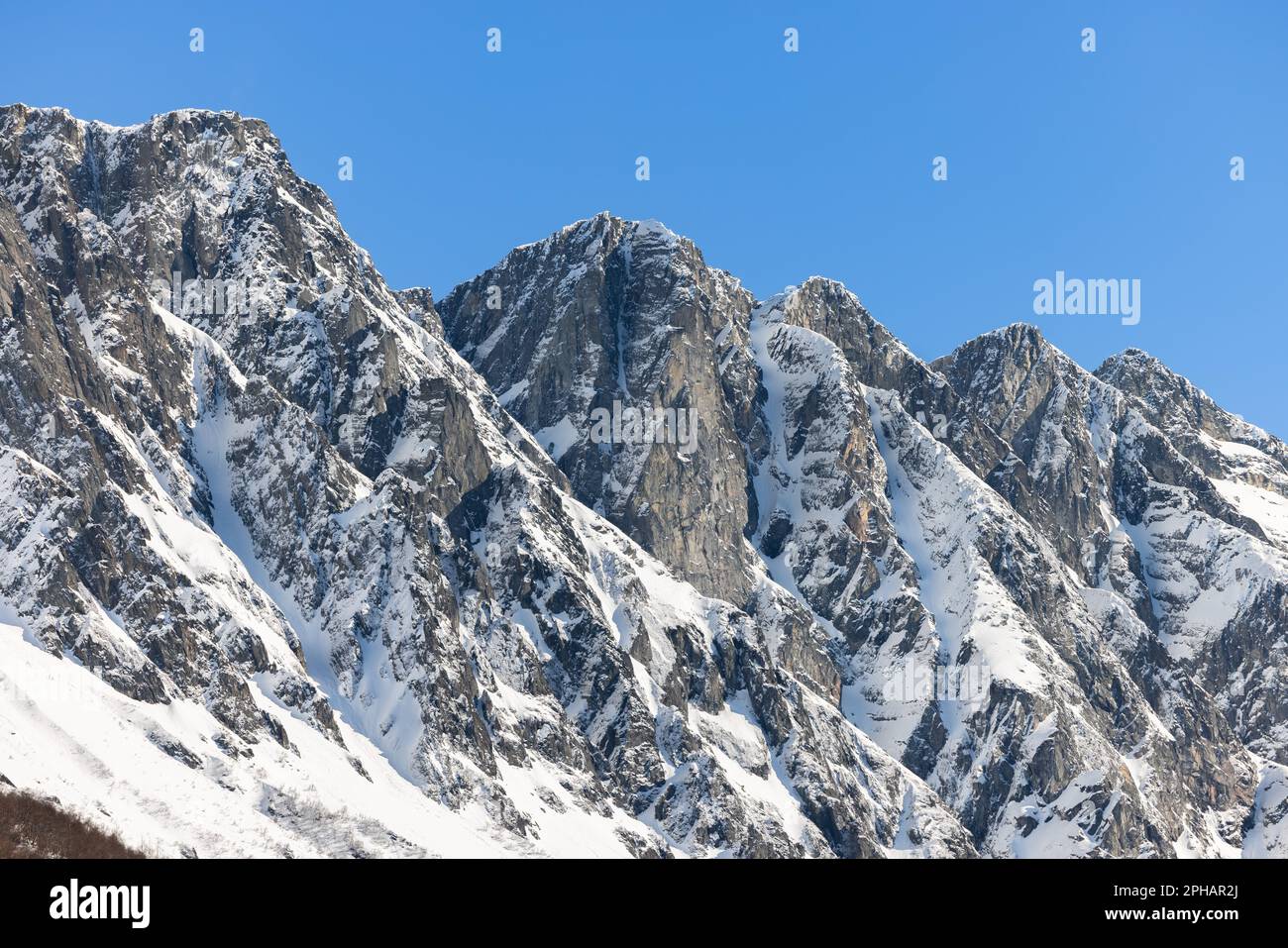 A majestic mountain range blanketed in freshly fallen snow under a ...