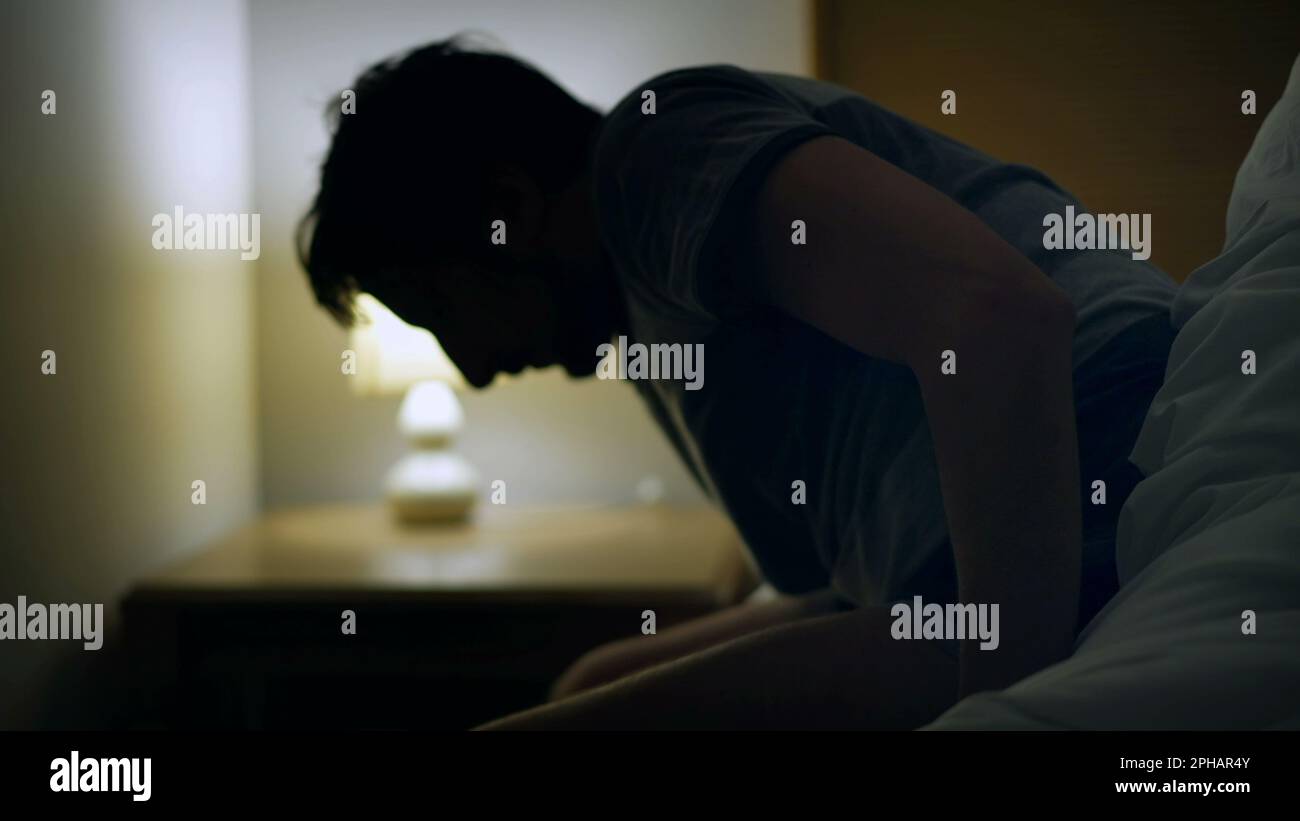 Man waking up getting out of bed in the middle of the night. Ealy wake
