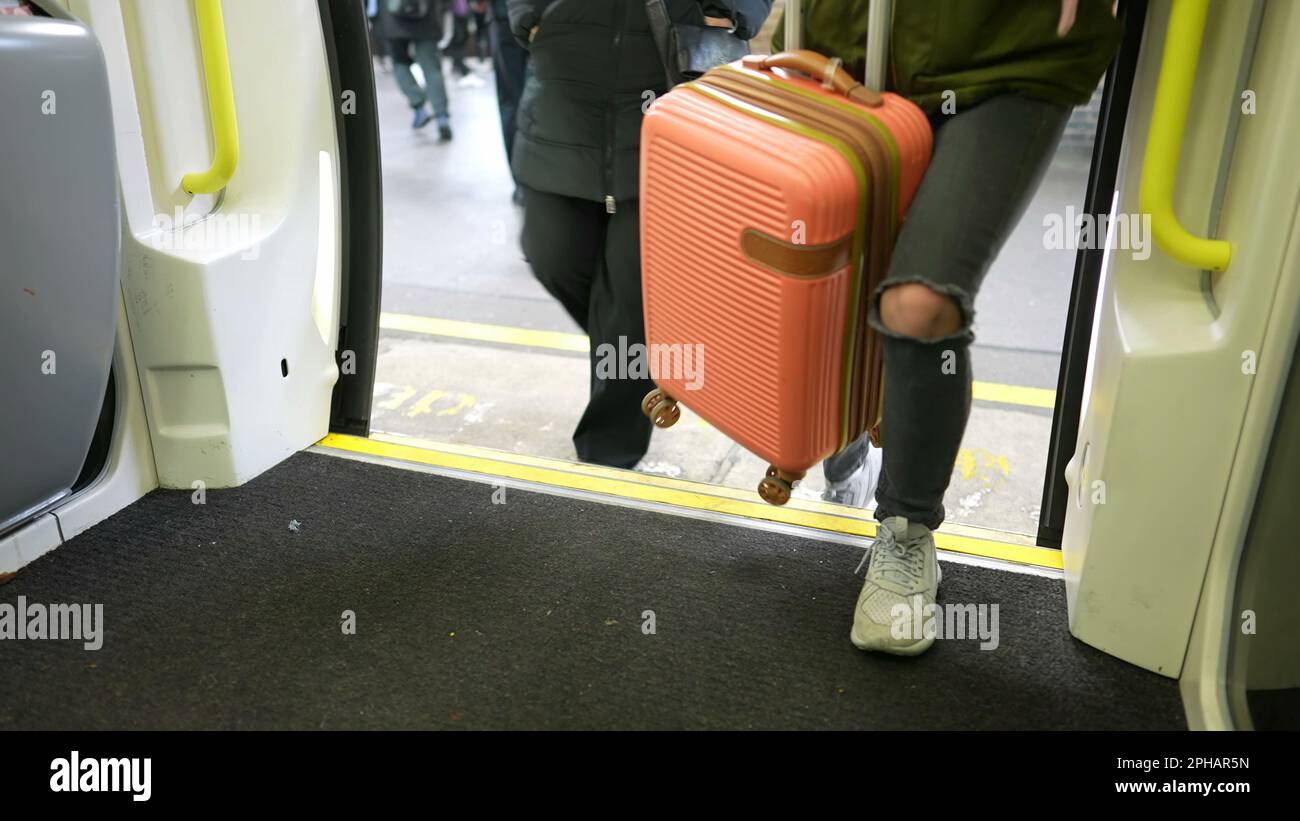 People leaving and entering subway train on platform. Close up legs on