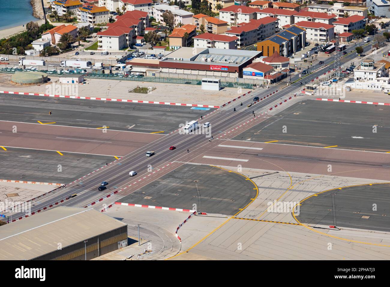 Vehicles cross the main runway of Gibraltar Airport. A tunnel has been proposed by the local Government and MOD. The British Overseas Territory of Gib Stock Photo