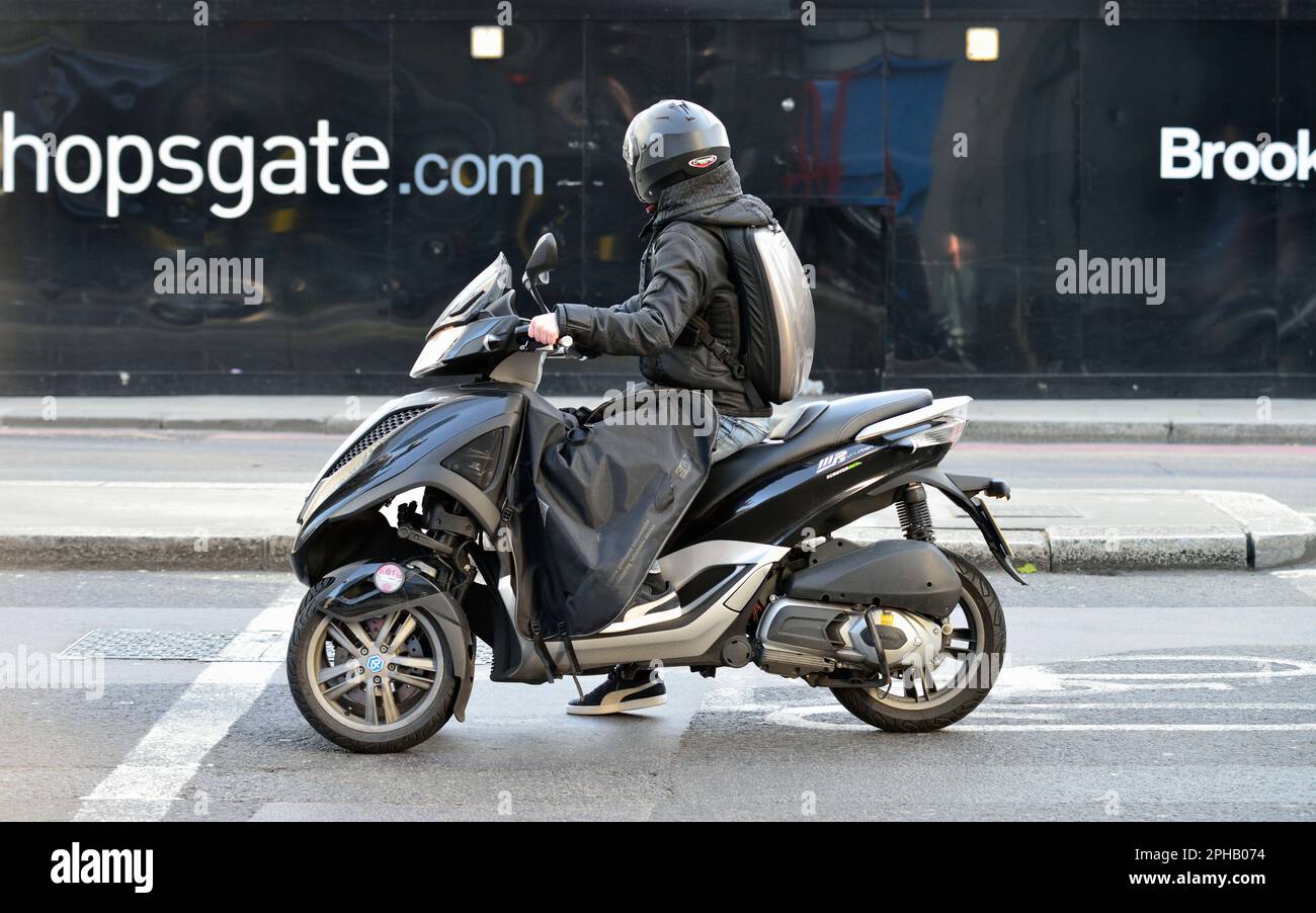 Three wheeled black Piaggio scooter, City of London, United Kingdom Stock Photo