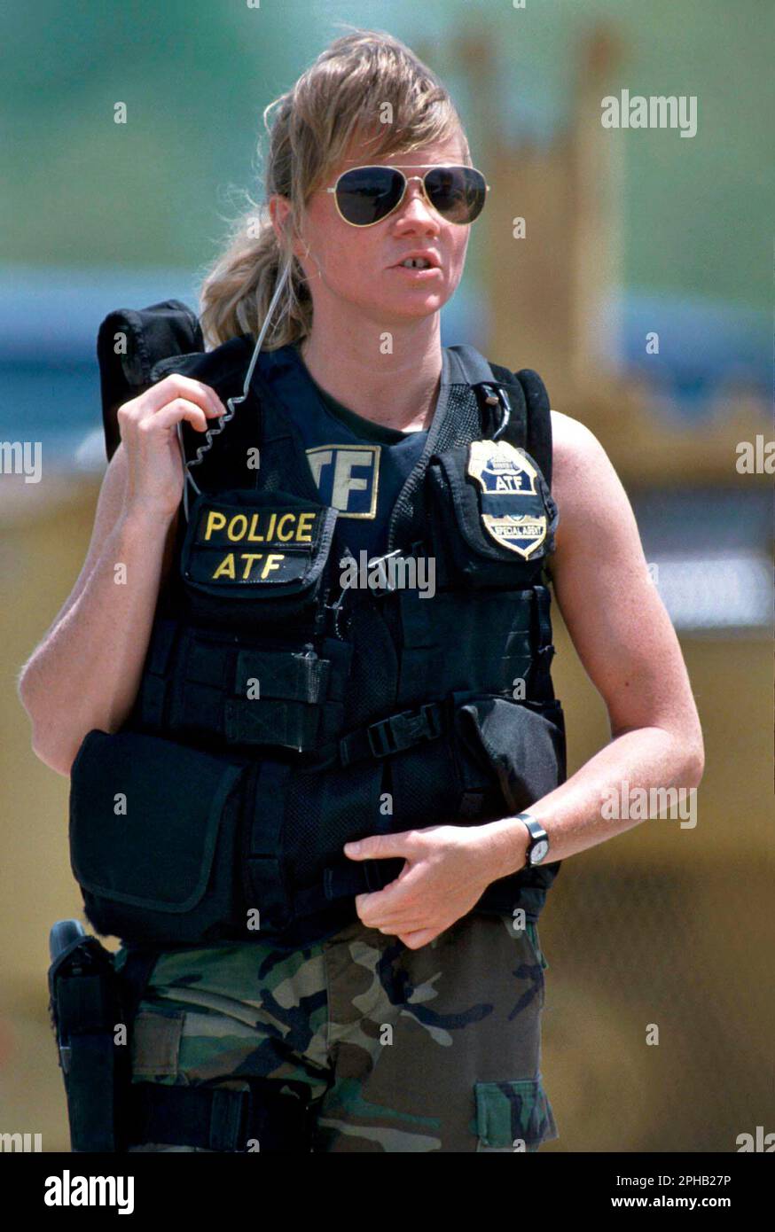 Waco, Texas USA, April 1993: Female agent in the Bureau of Alcohol, Tobacco and Firearms (ATF) wears a bulletproof vest and a communications earpiece is ready for action during the standoff between law enforcement agencies and the Branch Davidian religions group. ©Bob Daemmrich Stock Photo