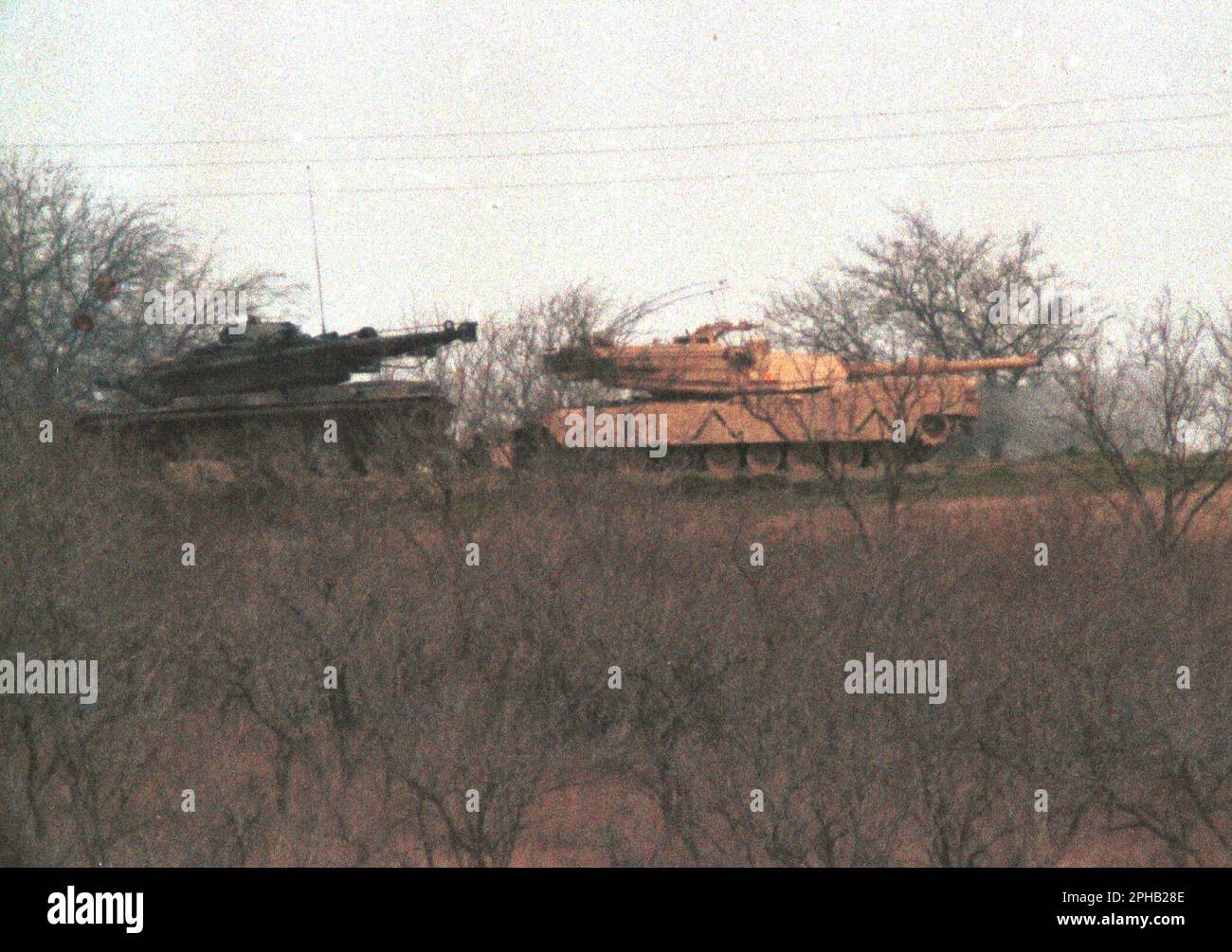 Waco, Texas USA, March 23, 1993: U.S. Army tanks from nearby Army post Fort Hood patrol the perimeter of the Branch Davidian compound in the midst of the 51-day standoff between federal law enforcement agents and Branch Davidian religious group members. The siege ended in a devastating fire that killed 76 men, women and children holed up in the compound.  ©Bob Daemmrich Stock Photo