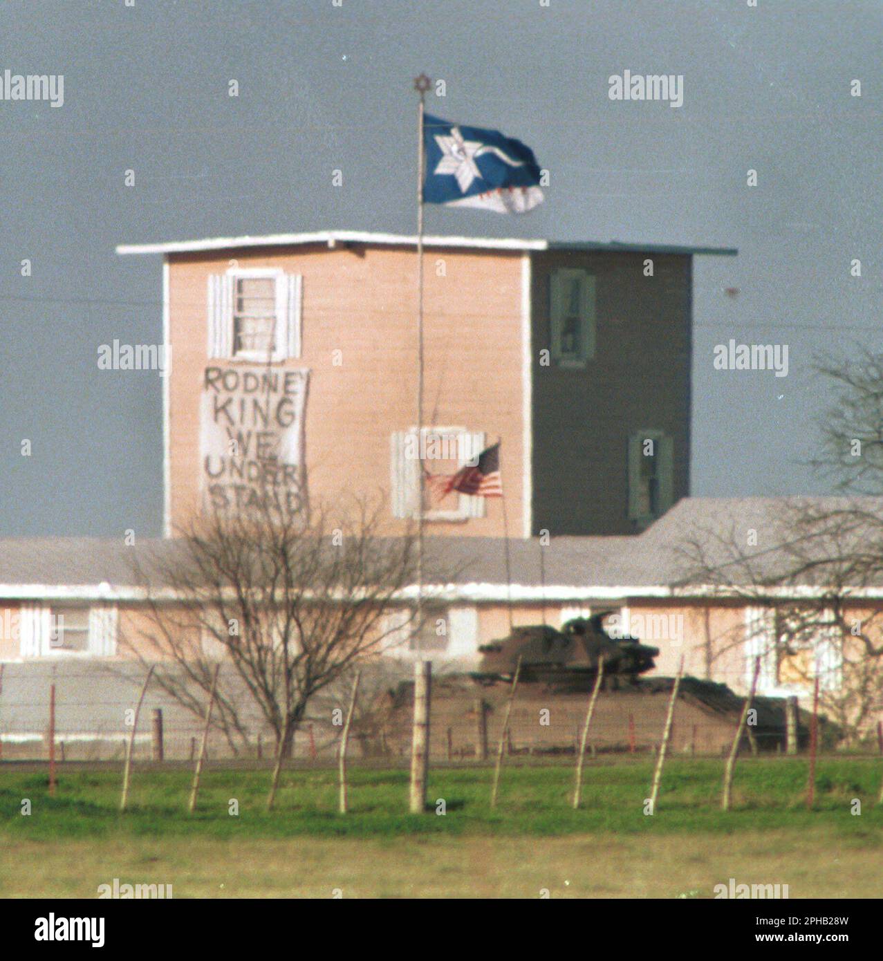 Waco, Texas USA, March 23, 1993: A U.S. Army tank drives past the Branch Davidian compound in the midst of the 51-day standoff between federal law enforcement agents and Branch Davidian religious group members. The siege ended in a devastating fire that killed 76 men, women and children holed up in the compound.  ©Bob Daemmrich Stock Photo