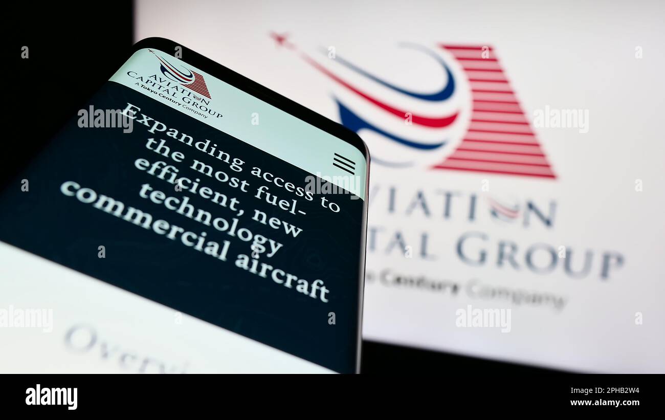 Smartphone with website of US leasing company Aviation Capital Group LLC on screen in front of business logo. Focus on top-left of phone display. Stock Photo