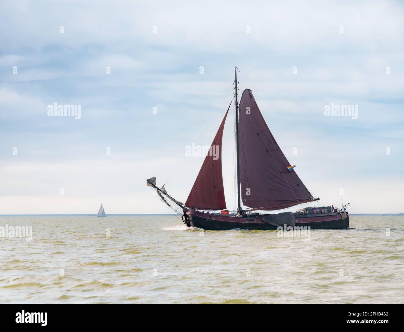 Traditional sail barge, tjalk, sailing with brown sails on IJsselmeer lake, Netherlands Stock Photo