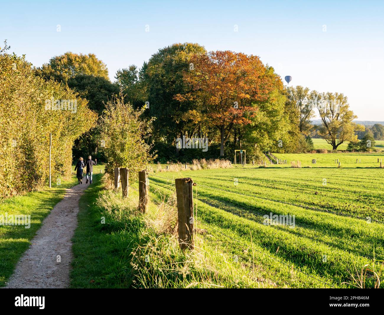 Older couple walking on footpath through nature near town of Ootmarsum, Overijssel, Netherlands Stock Photo
