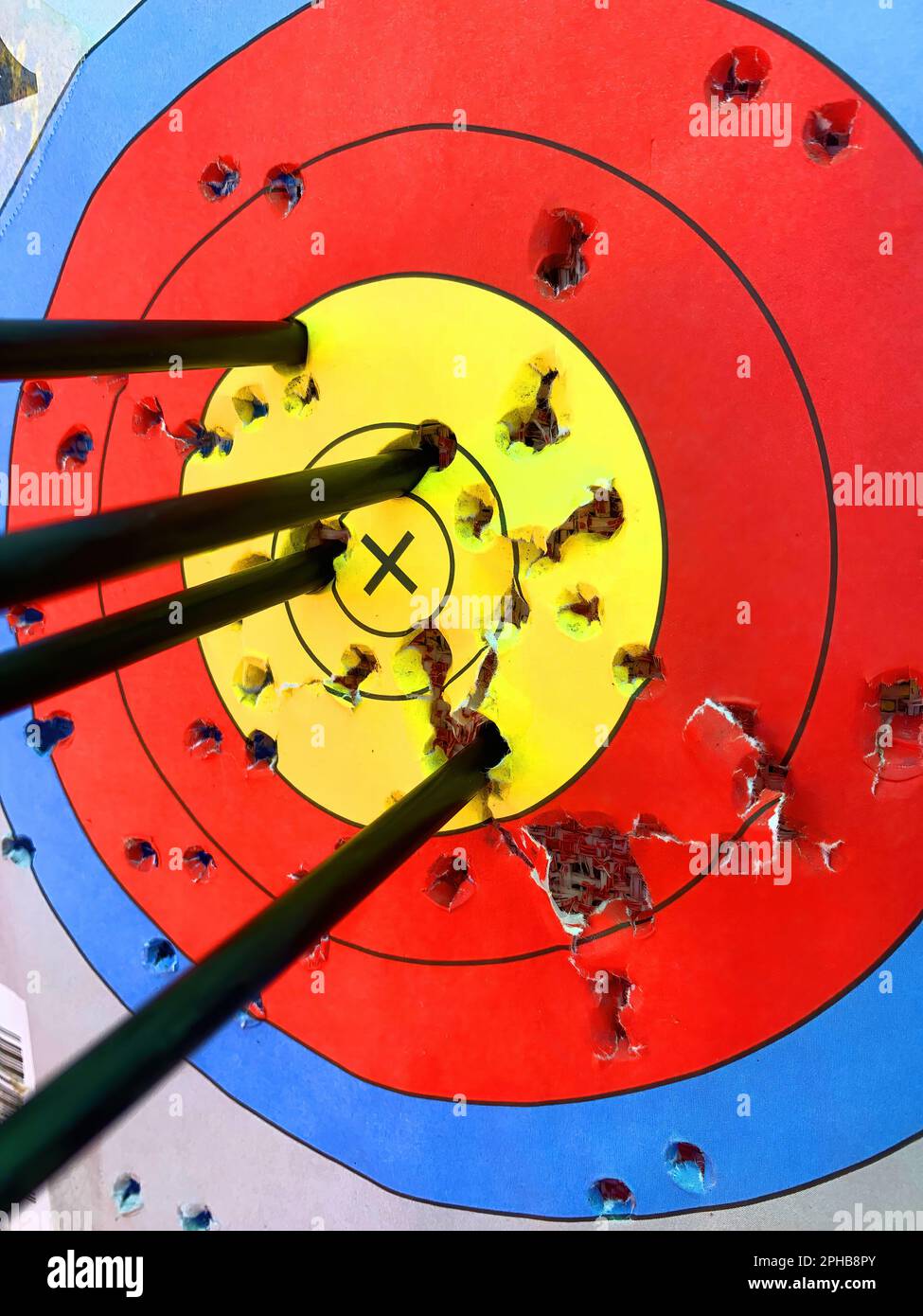 Archery target with all arrows in the gold center ring Stock Photo Alamy