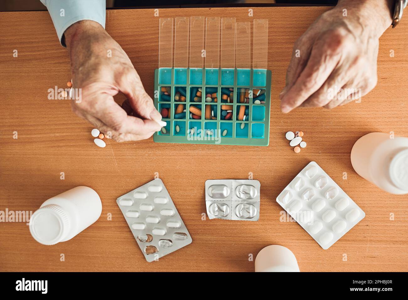 Senior man organizing his medication into pill dispenser. Senior man