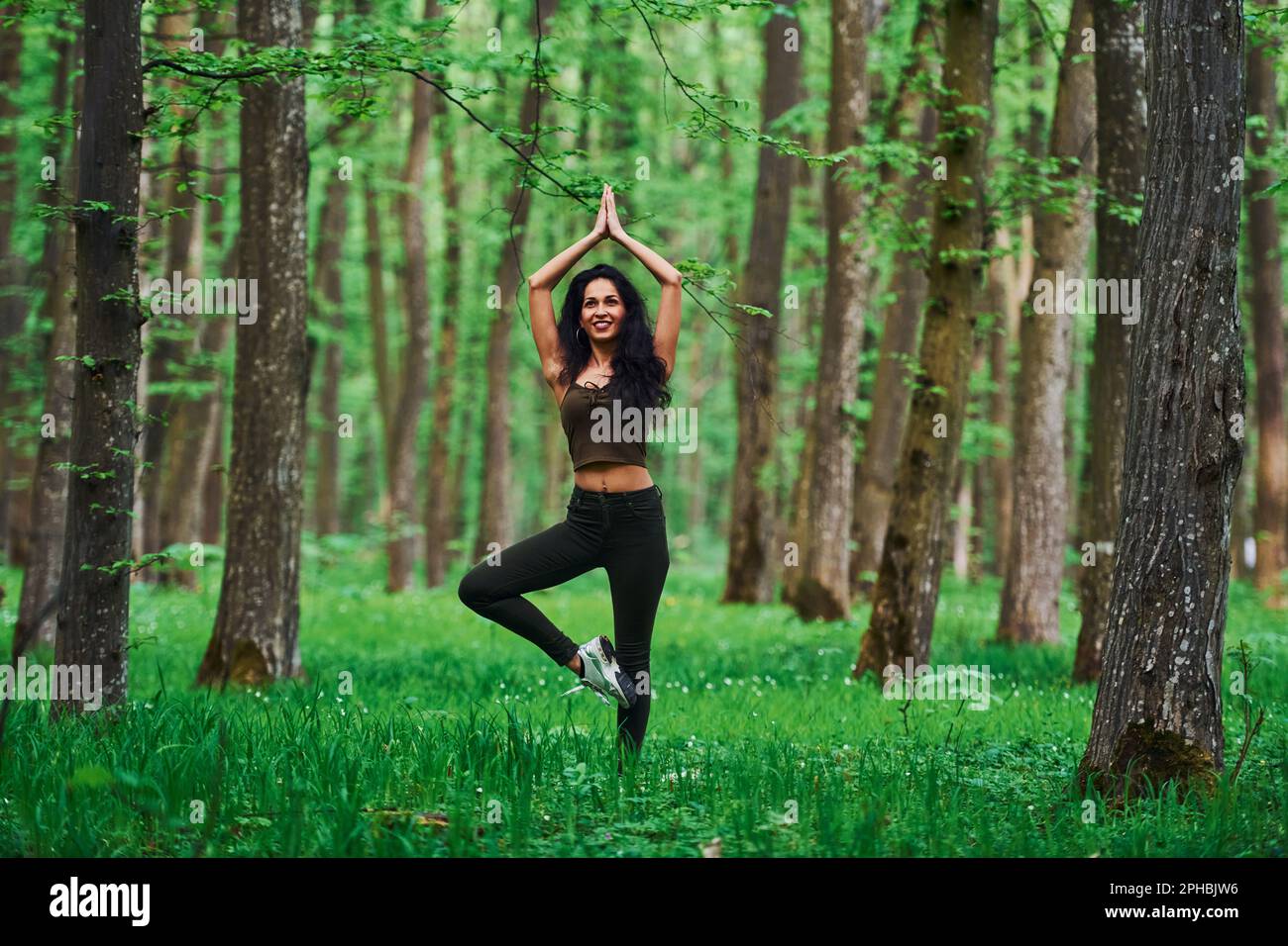 Positive brunette doing fitness outdoors in the forest at daytime Stock ...