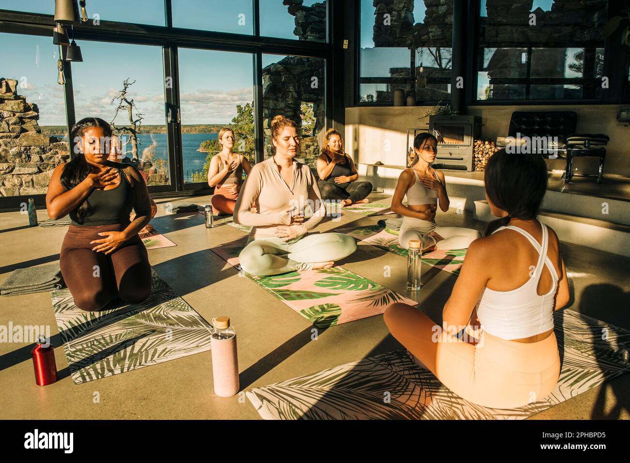 Female coach practicing breathing exercise with women at retreat center