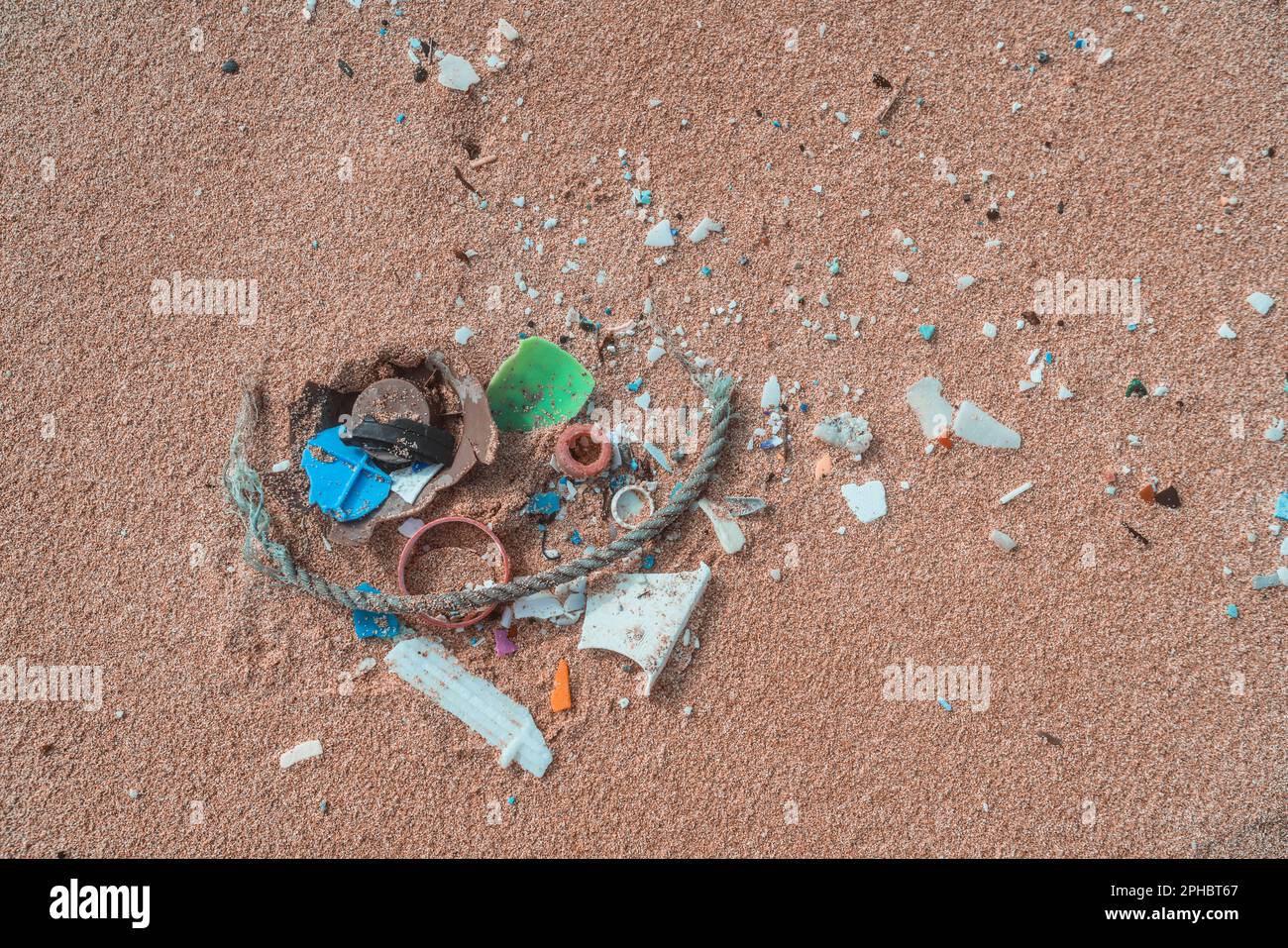 Plastic pollution on shore of beach. Ocean microplastic marine debris Stock Photo