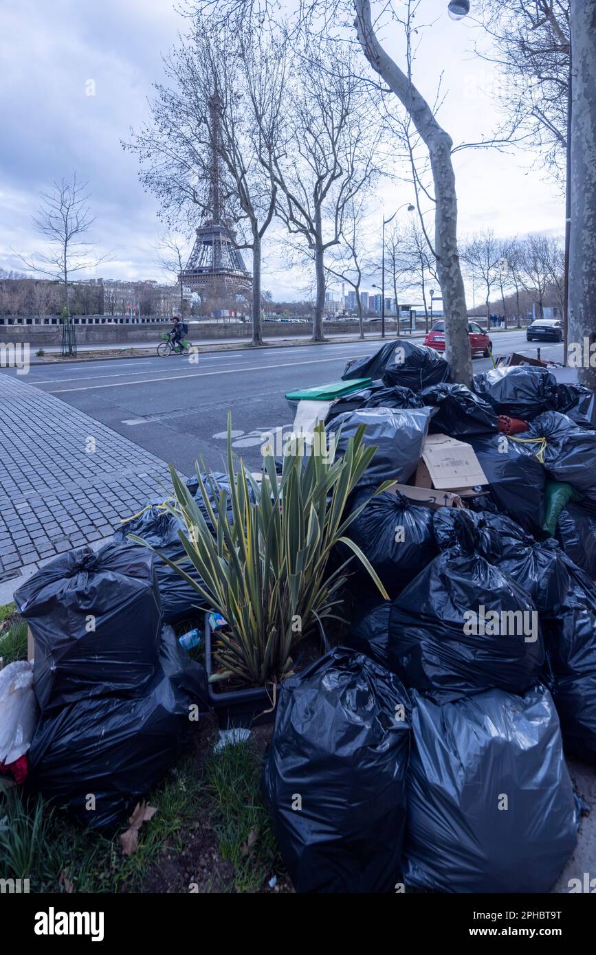Paris, France, 26 March 2023. Due to refuse collectors striking against Macron's reform of pension laws, trash bags pile up on the pavements of Paris within sight of major tourist landmarks like the Eifel Tower Stock Photo