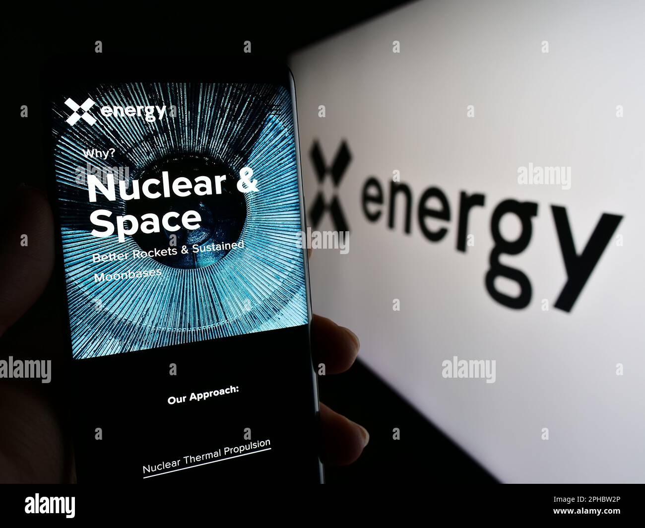 Person holding cellphone with webpage of US nuclear energy company X