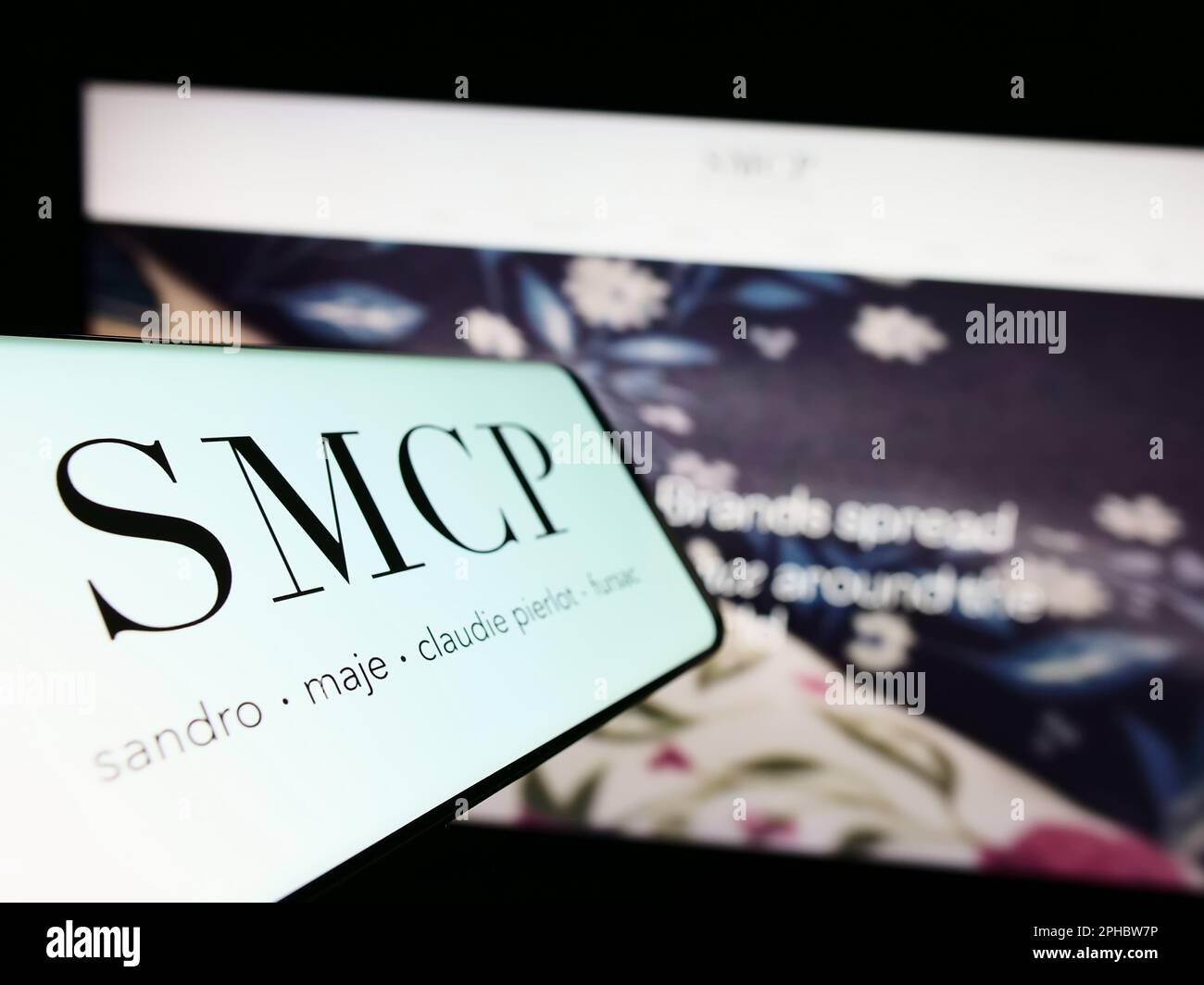 Smartphone with logo of French luxury fashion company SMCP SA on screen in front of business website. Focus on center-left of phone display. Stock Photo
