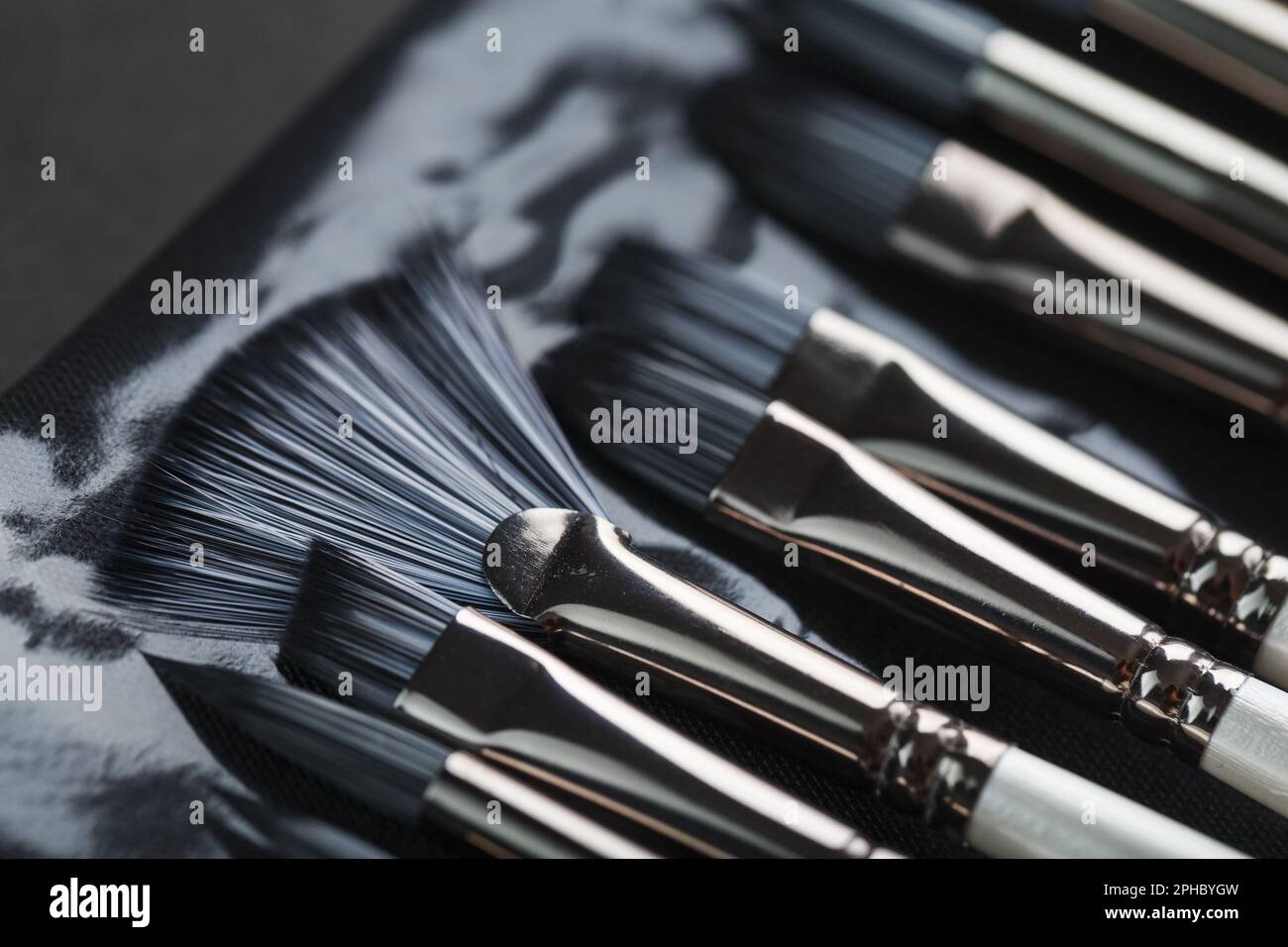 Paint tubes, brushes for painting and palette knifes on old wooden background. Close-up Stock Photo