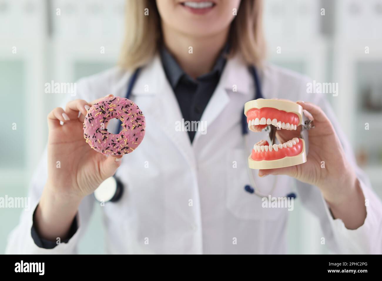 Dentist explains impact of sweets on teeth health in clinic Stock Photo