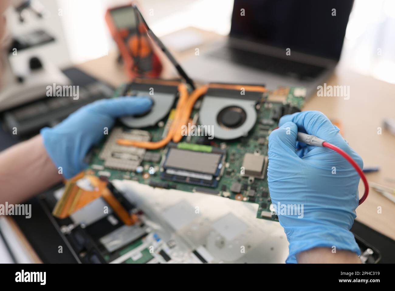 Repairman in gloves checkups computer motherboard in shop Stock Photo