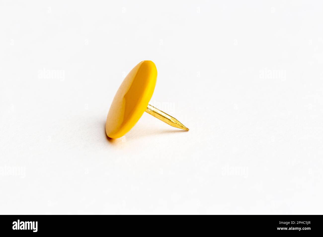 Single yellow metal drawing pin Stock Photo